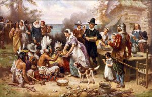 A Thanksgiving feast with the Indians and the Pilgrims sharing foods. 
