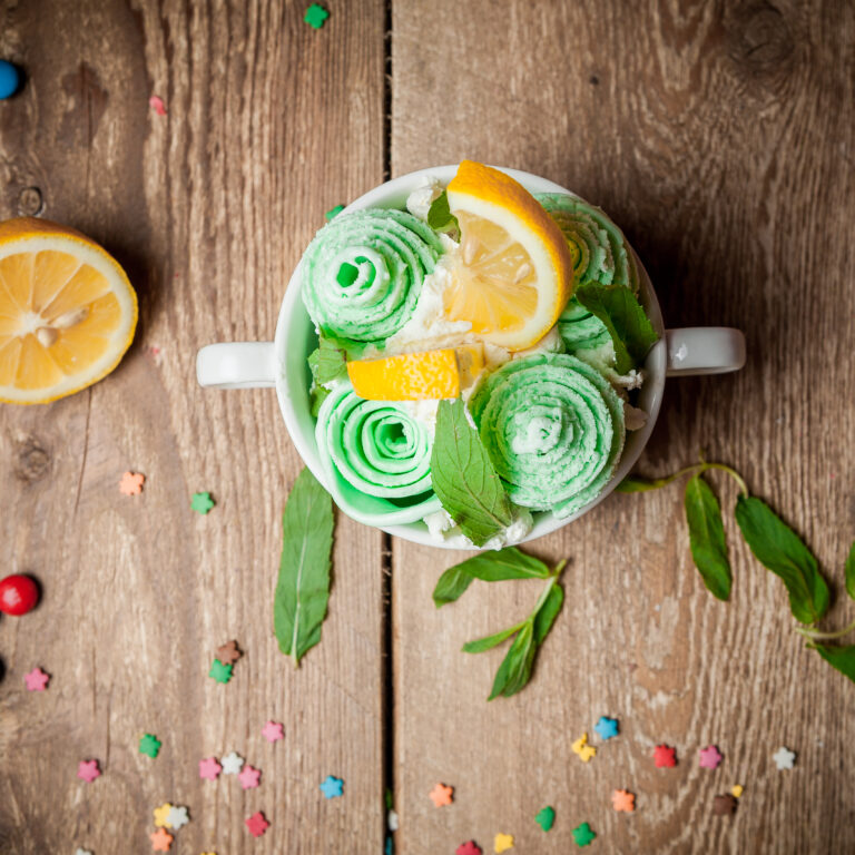 Top view peppermint ice cream with lemon and mint leaves in cup on wooden background