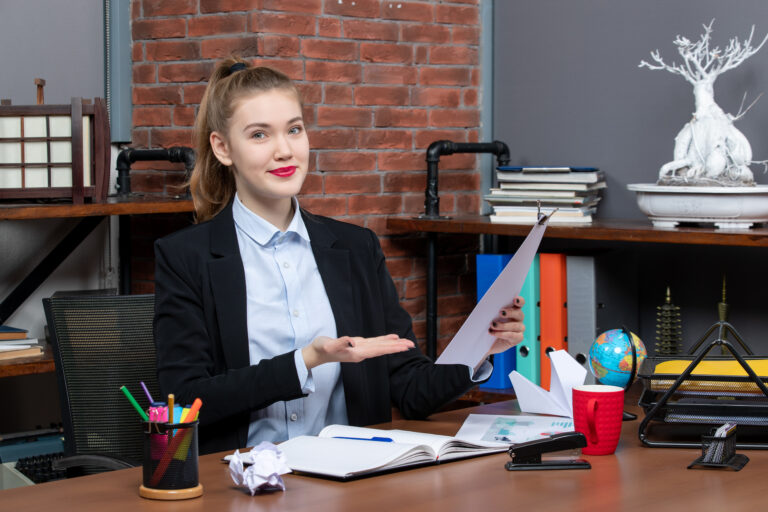 top-view-young-female-sitting-table-showing-document-office